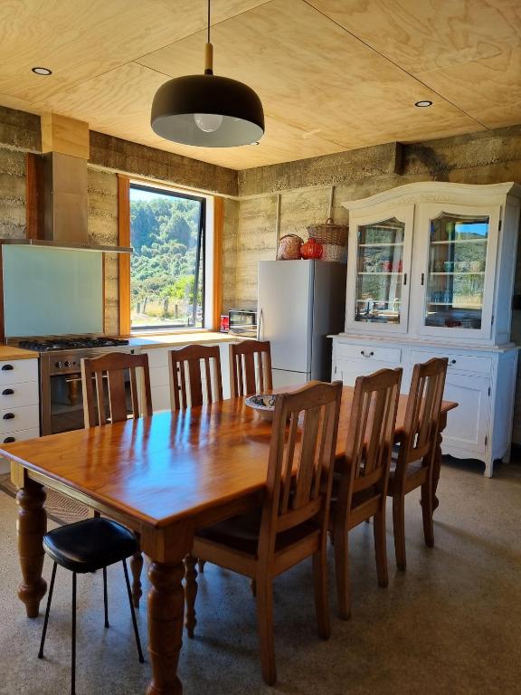 a kitchen with a wooden dining table and chairs at Pikikirunga House, Takaka Hill in Upper Takaka
