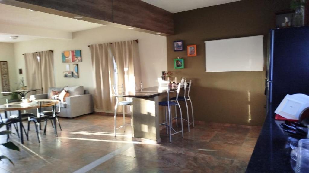 ein Wohnzimmer mit einer Bar, einem Tisch und Stühlen in der Unterkunft Flor silvestre in Carpintería