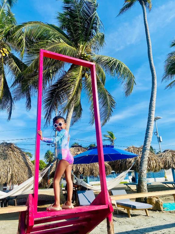 a little girl sitting on a chair on the beach at Hotel Los Nogales Coveñas in Coveñas