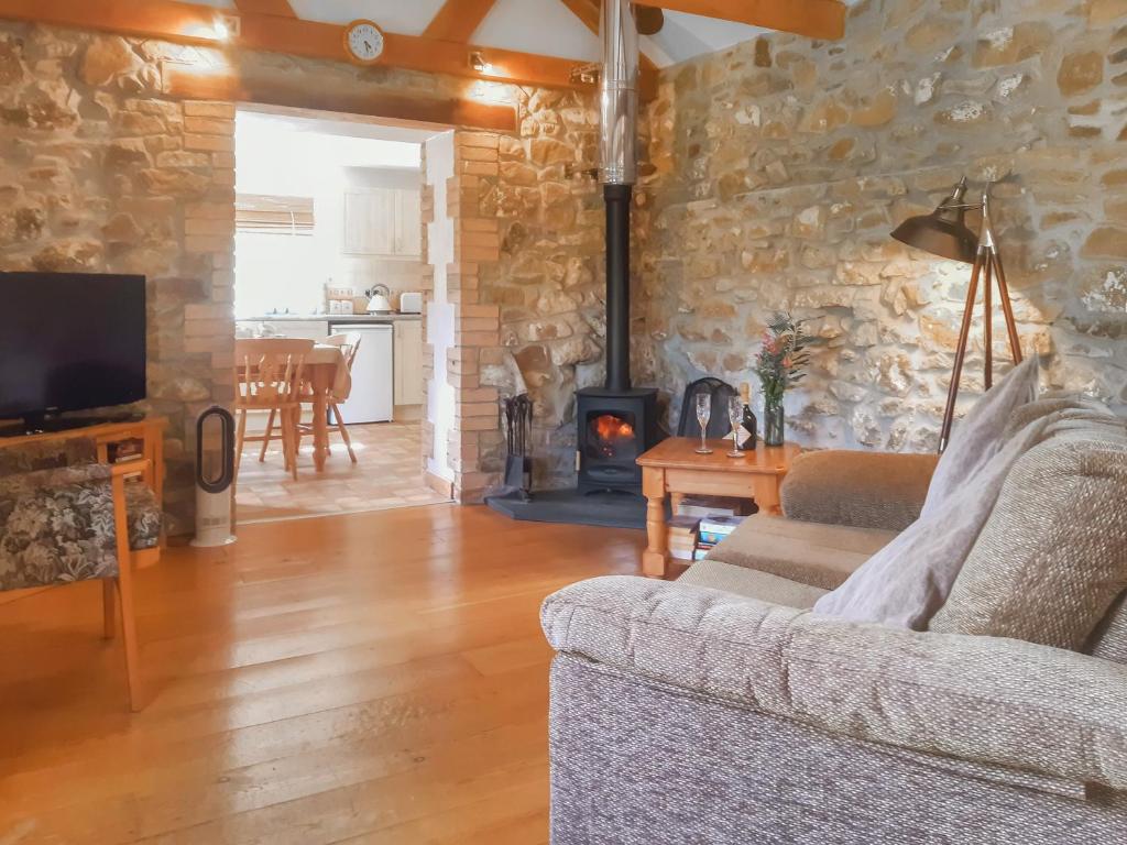 Mount HawkeにあるThe Old Dairyのソファと暖炉のあるリビングルーム