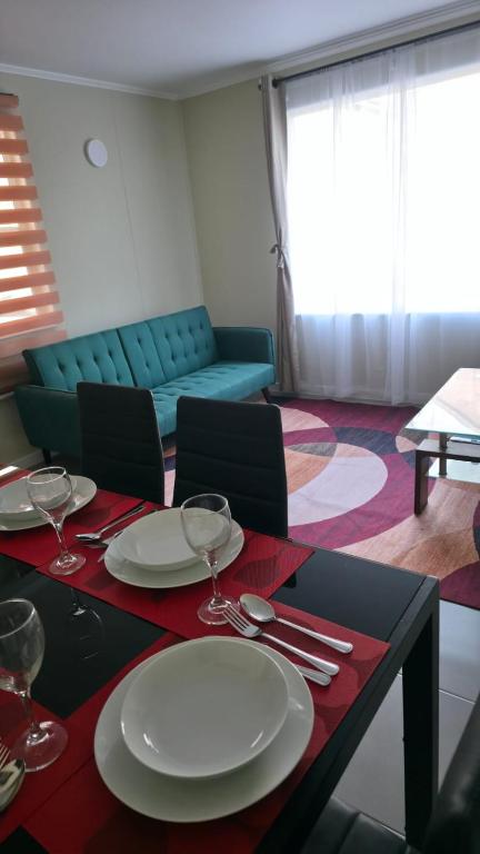 a living room with a table with plates and wine glasses at Refugio tranquilo en Bosquemar in Puerto Montt