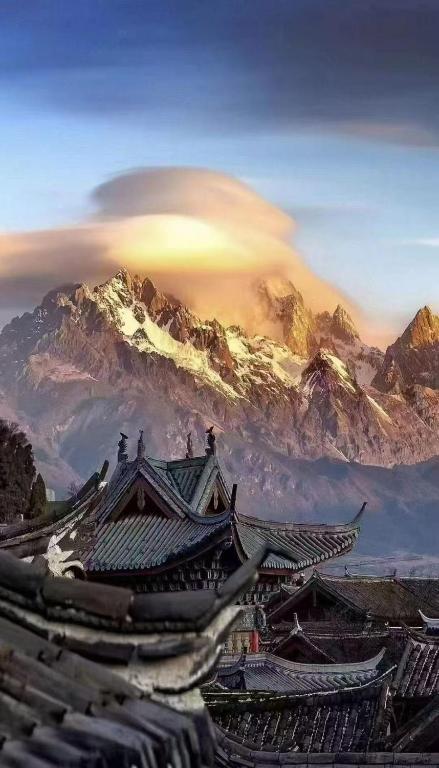 a view of a mountain with buildings and roofs at Blessing of the Dragon's Whisper Inn in Lijiang