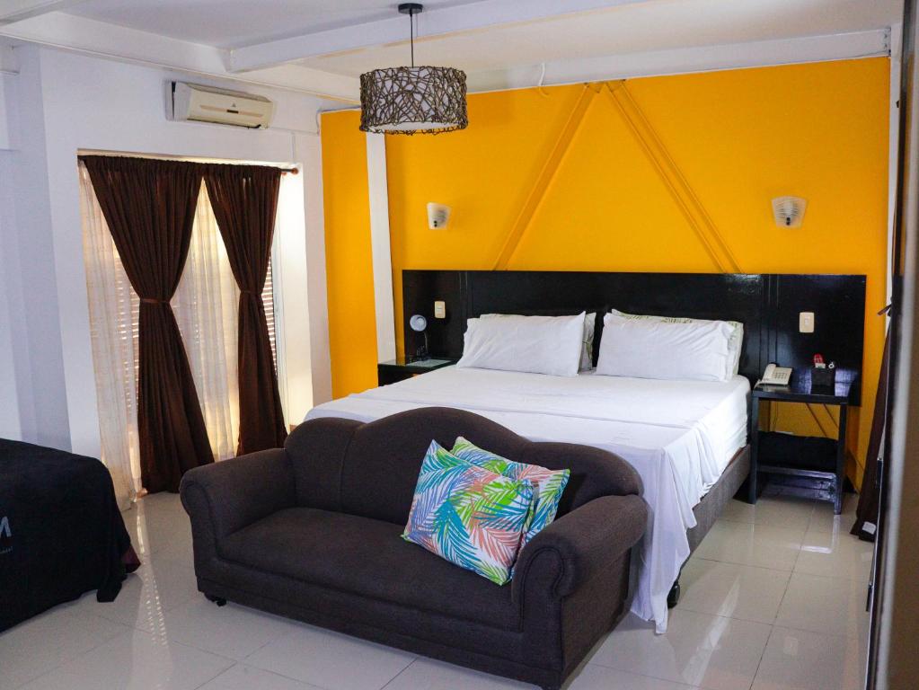 a bedroom with a large bed and a chair at Hotel H&M in Palmira