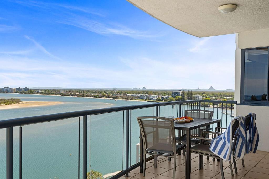 balcón con mesa y sillas y vistas al agua en Seaside Solace at Caloundra Seaview 3BD Apartment, en Caloundra