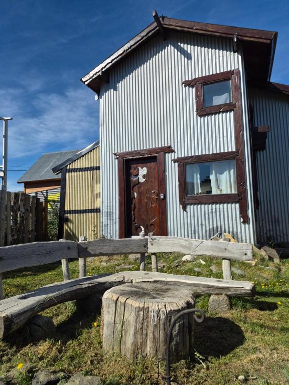 a wooden bench sitting in front of a building at KUNTUR 2 Cabañas in El Chalten