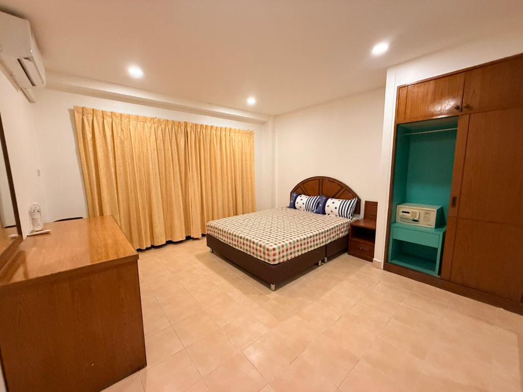 Un dormitorio con una cama y una cómoda. en Jasmine Villa Soi Buakhao, en Pattaya central