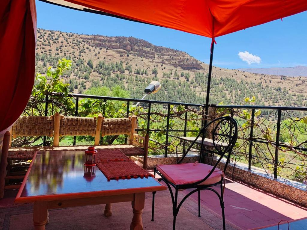 a patio with a table and chairs and an umbrella at Hôtel Tawada in Azilal
