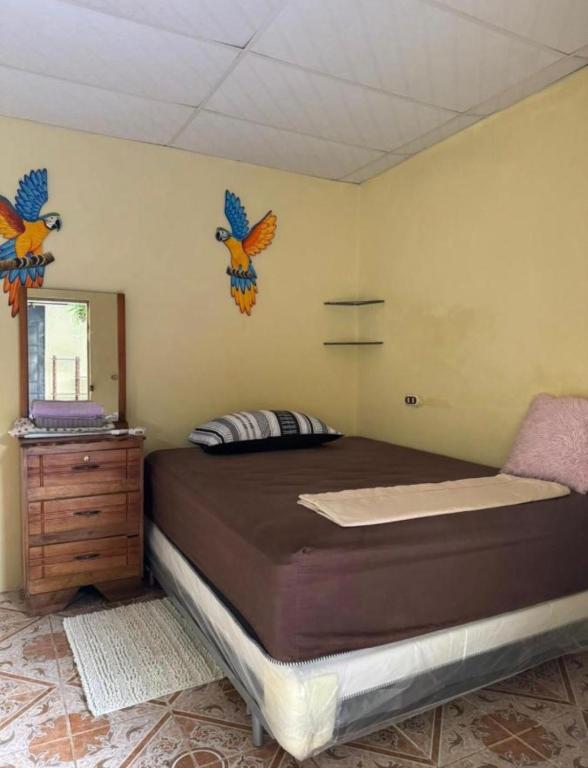 a bedroom with a bed with birds on the wall at Cute House in Sonsonate