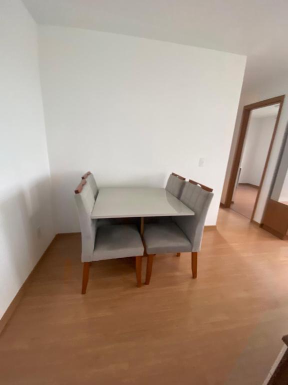 una mesa y una silla en una habitación en Residencial Dalí, en Duque de Caxias