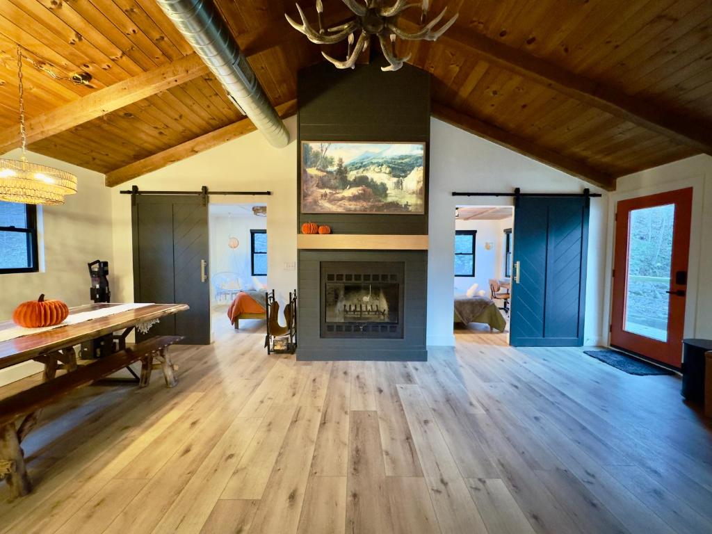 a living room with a fireplace and a table at Cozy Creekside cabin- 35m to Boone in Butler