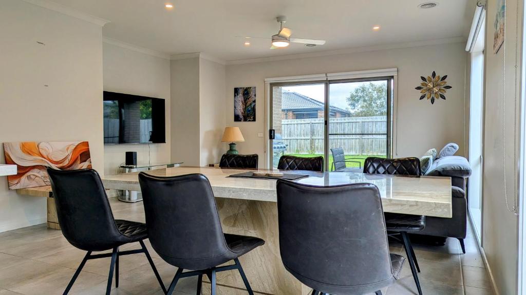 Un comedor con mesa y sillas en Comfy & spacious home near Bellarine Rail Trail, en Curlewis