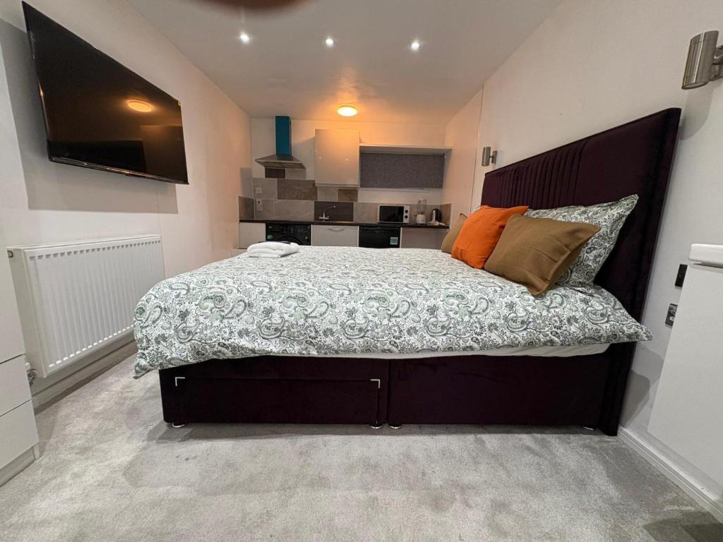 a bedroom with a large bed and a kitchen at WBC R4 - Private Studio Room in Bilston