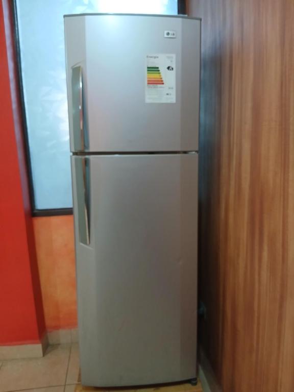 a white refrigerator sitting next to a wooden wall at Departamento Céntrico in Quillacollo