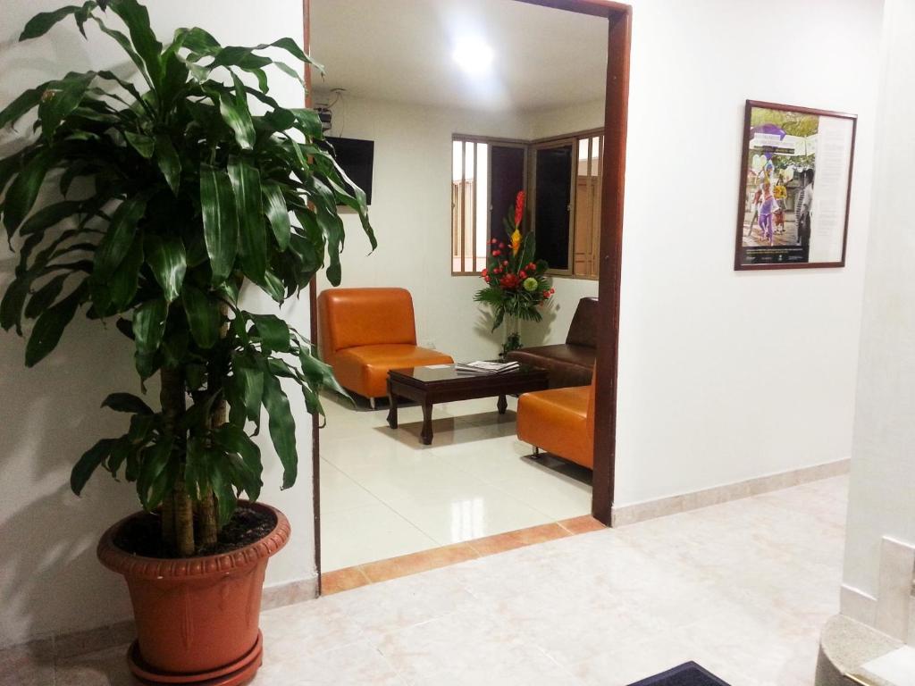 a living room with a plant in a pot at Hotel Center in Ibagué