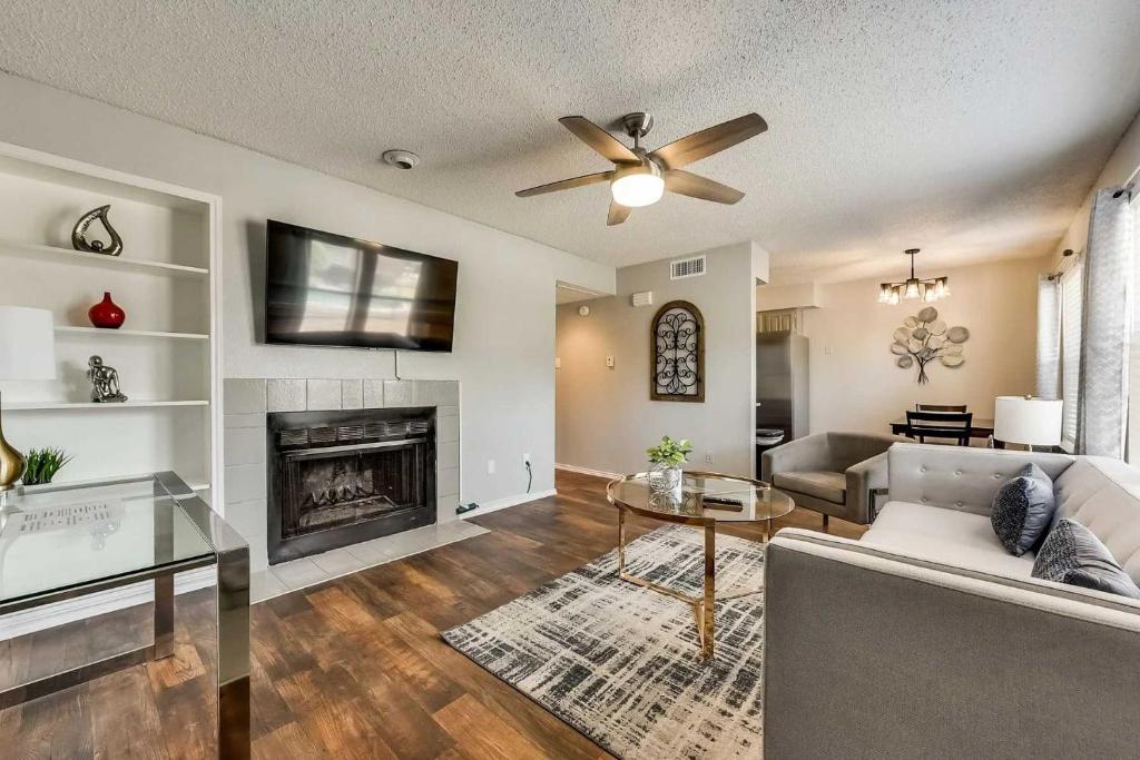 una sala de estar con un sofá y una chimenea en Upgraded 1BD condo Pool Irving I45, en Sowers