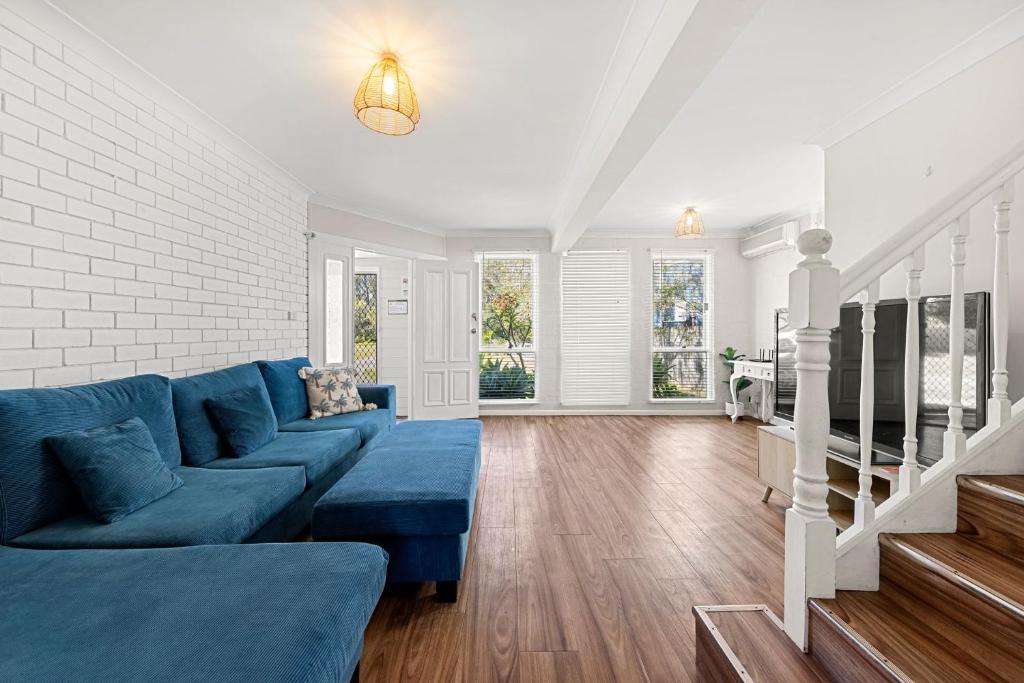 a living room with a blue couch and a brick wall at Shelleys - Pet Friendly - Short Walk to Beach in Orient Point