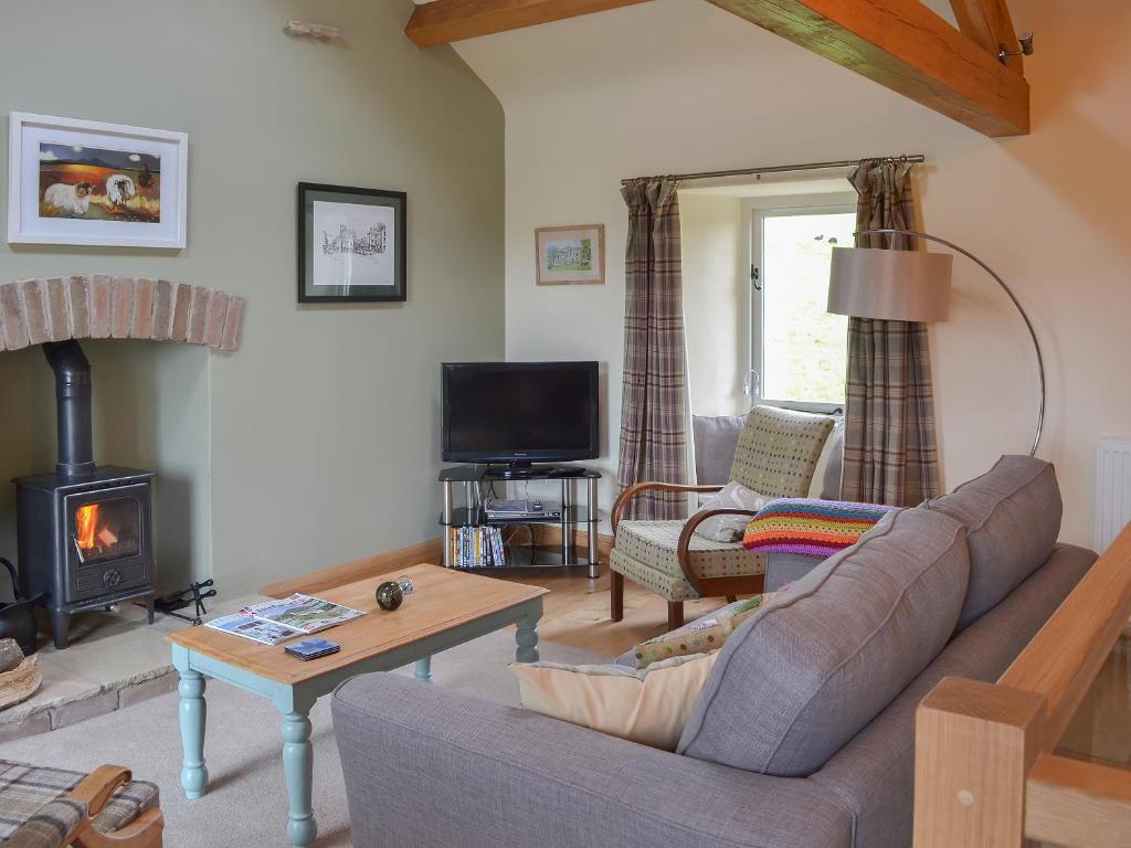 a living room with a couch and a fireplace at Brow View Cottage in Ravenstonedale