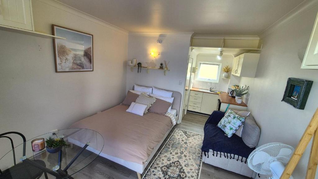 a small bedroom with a bed and a table at Kiama Dreams in Kiama