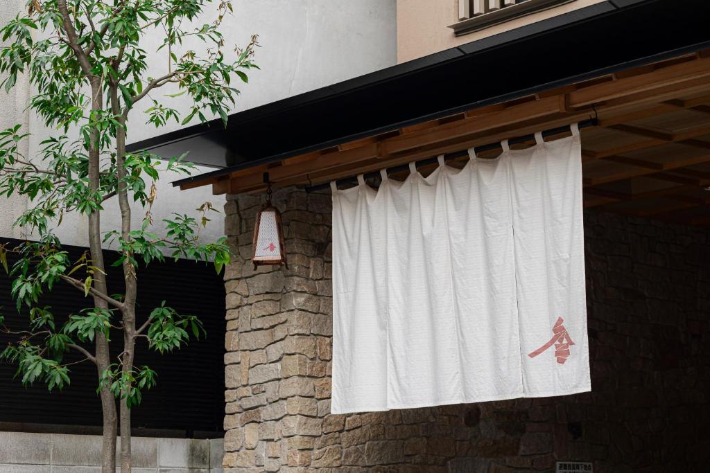 a window with a white curtain on the side of a building at soyo-ka kyoto sanjo in Kyoto