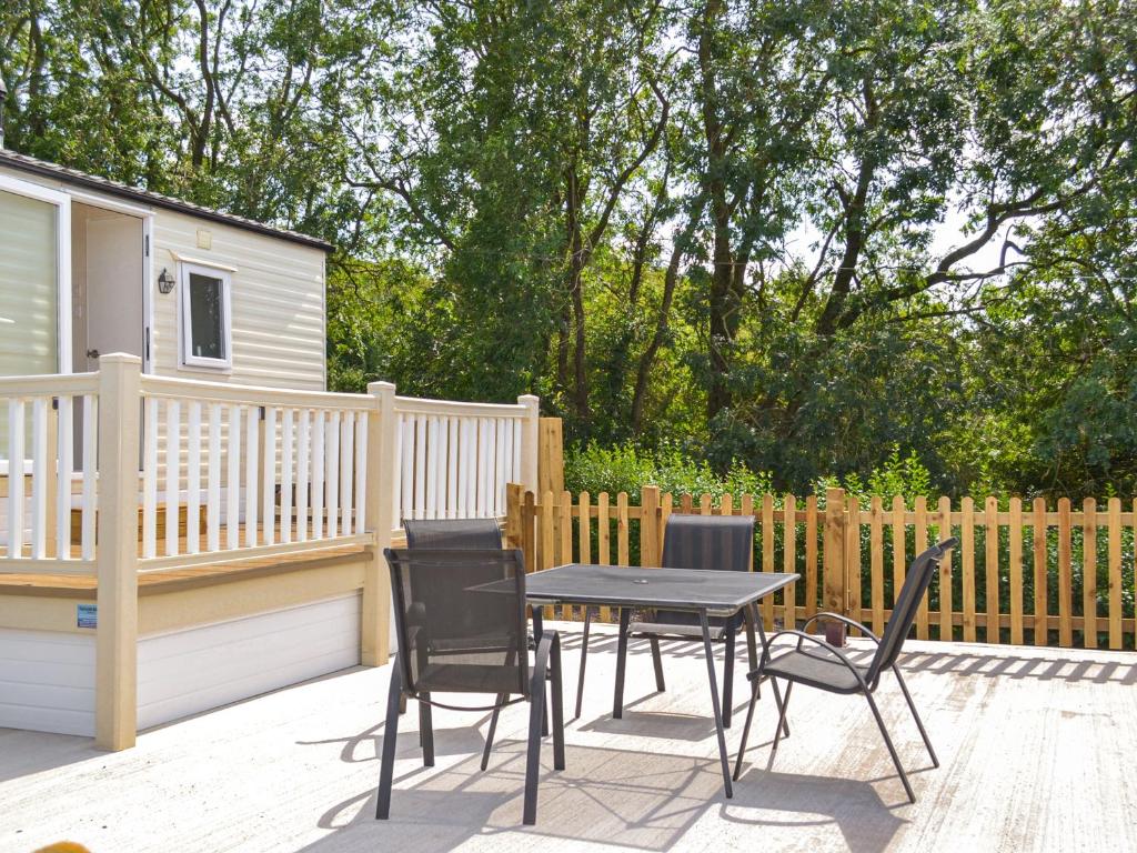 Un patio con una mesa y sillas en una terraza. en Hillcrest Caravan - Uk44798, en Hemswell