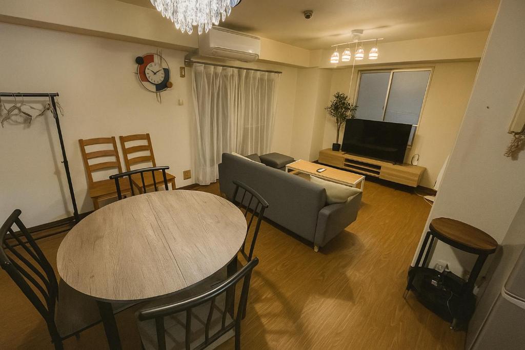Una sala de estar con una mesa, un sofá y un televisor. en r311 Spacious Apartment near Dotonbori Namba Walk to Nipponbashi, en Osaka