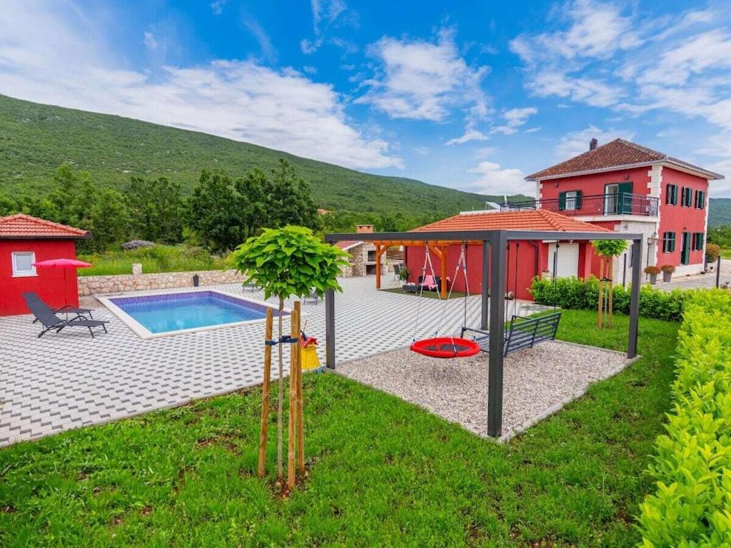 een achtertuin met een zwembad en een huis bij Holiday home in Slivno with swimming pool in Slivno