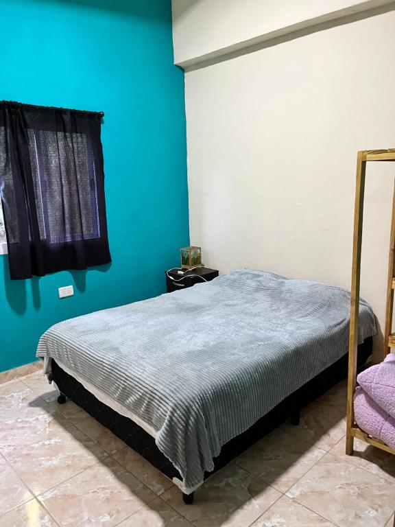 a bedroom with a bed with a blue wall at Alojamiento MD in Wanda