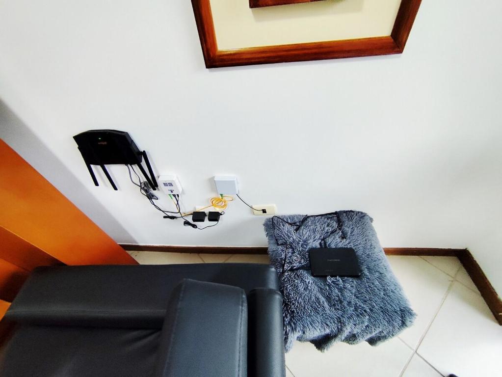 een woonkamer met een zwarte bank en een deken bij Hosting in Naguanagua in Naguanagua