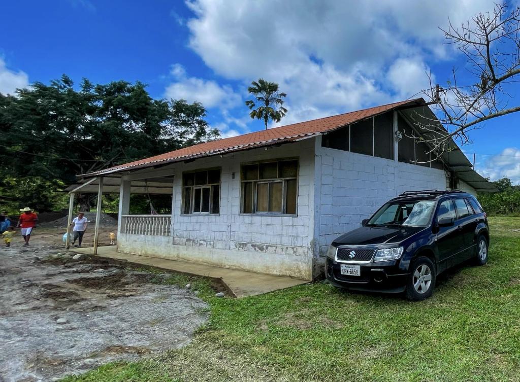 ein Auto, das vor einem kleinen Haus parkt in der Unterkunft Cabaña Flor Hermosa in Santo Domingo de los Colorados