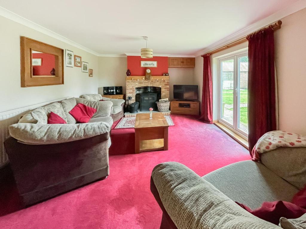 sala de estar con 2 sofás y alfombra roja en Homestead, en Long Sutton