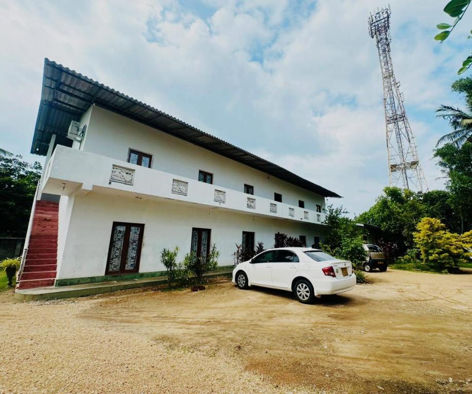 a white car parked in front of a house at Viyan hotel in Negombo