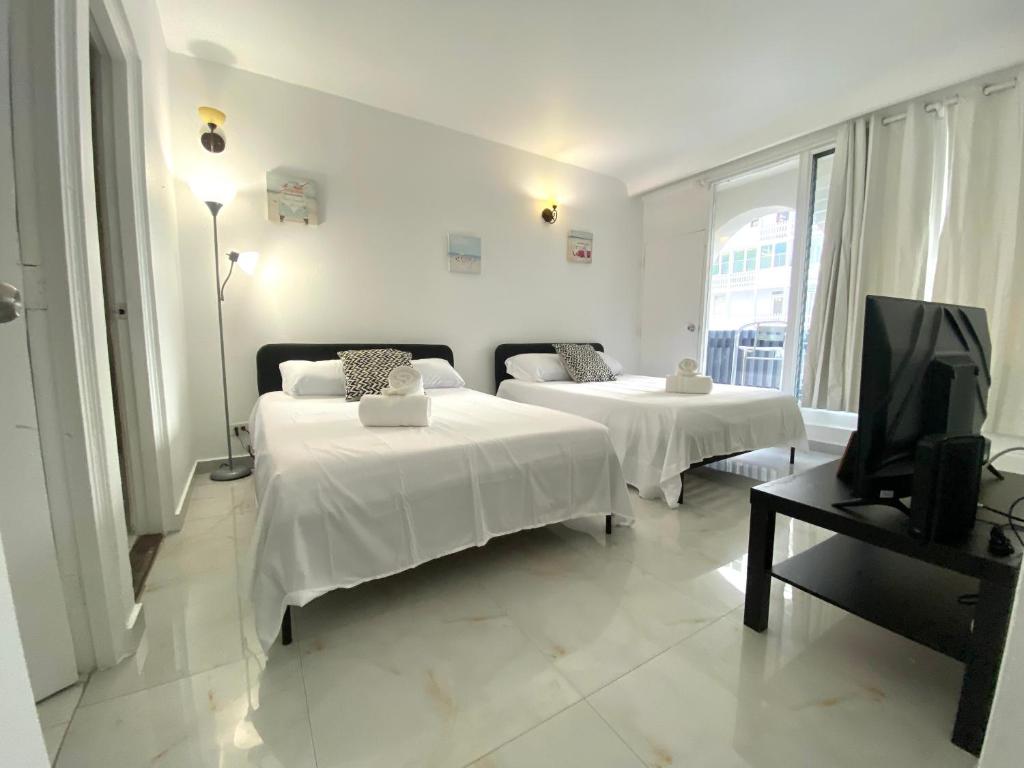 a hotel room with two beds and a television at Condado Serenity by the Sea in San Juan