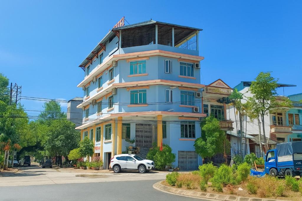 a blue building with a car parked in front of it at Thanh Hà Hotel Lào Cai in Lao Cai