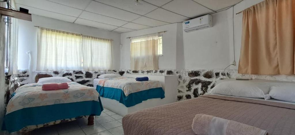 a bedroom with two beds and a window at Cabañas Don Jorge - Cabaña Fragata in Puerto Baquerizo Moreno