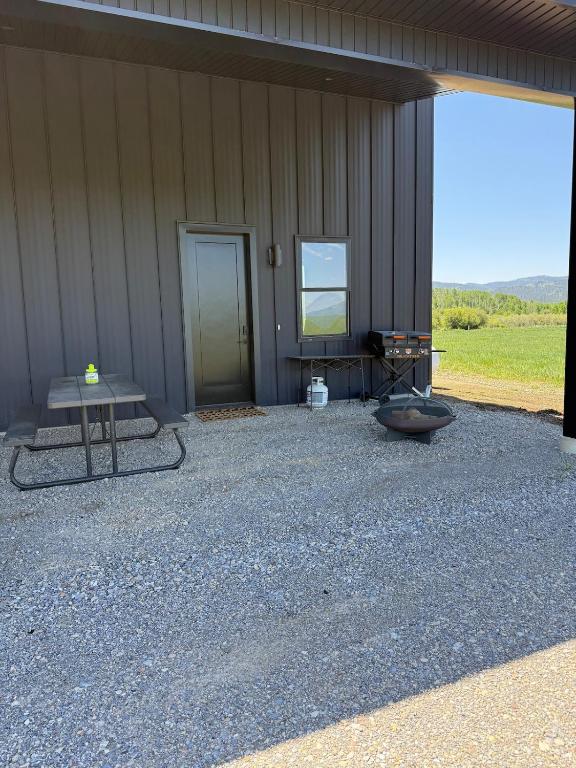 een zijkant van een gebouw met een tafel en een deur bij Star Valley Barndominium Unit B in Thayne