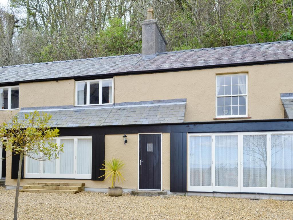 a house with white and black garage doors at Granary Cottage in Penrhyn Bay