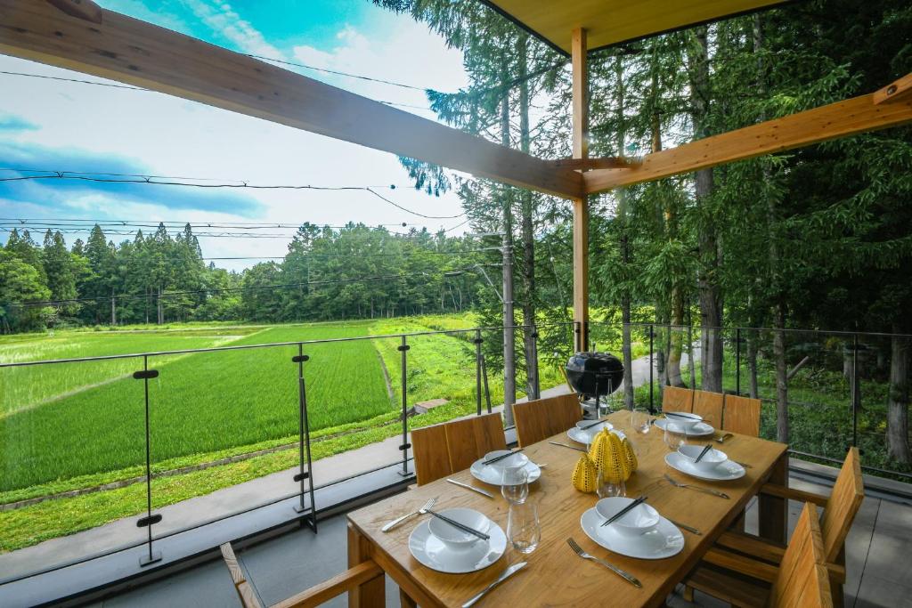 a wooden table in a room with a large window at Yamaemi, Spacious luxury chalet 5br, onsen bath in Hakuba