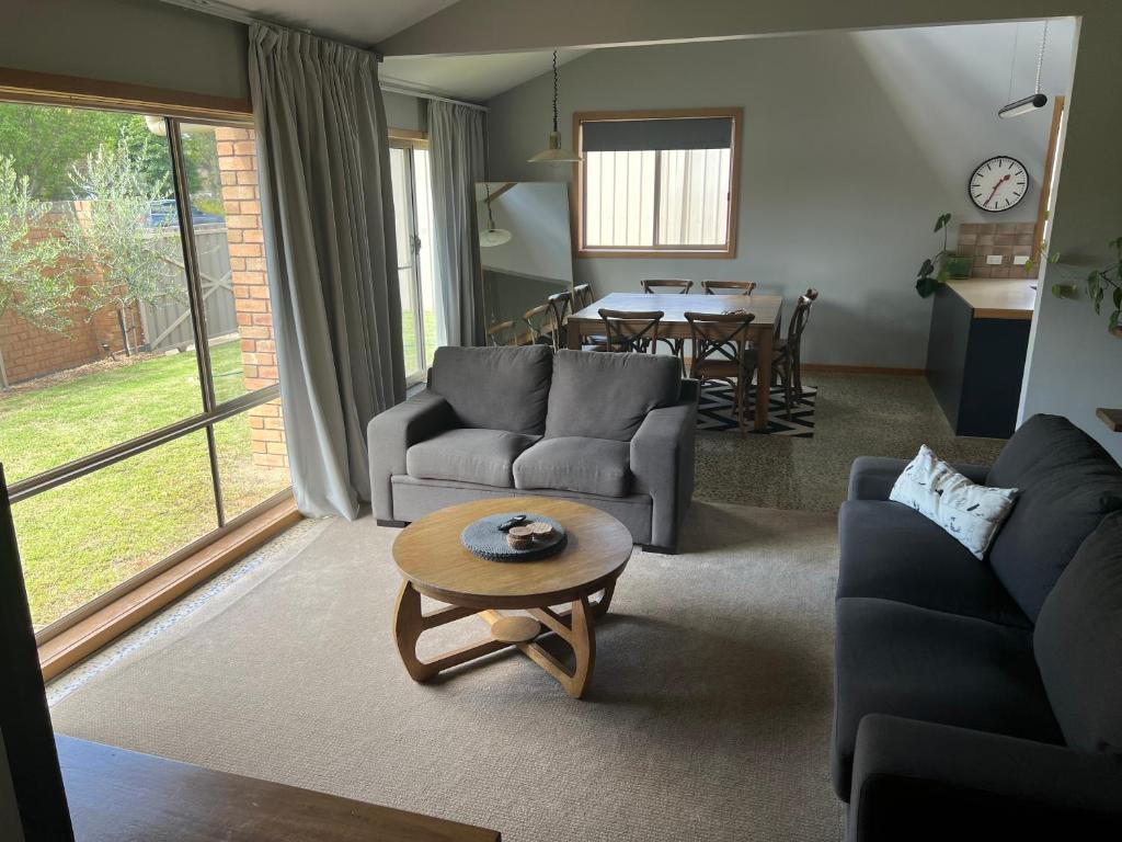 una sala de estar con un sofá y una mesa en Central Comfort, en Shepparton