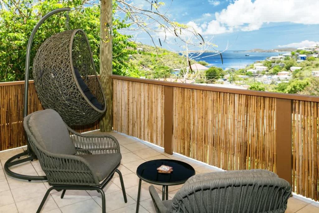 a porch with two chairs and a swing at Oceanview Escape Walk to Cruz Bay & Beaches in Enighed