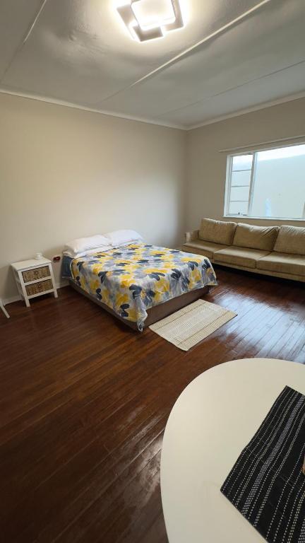 Un dormitorio con una cama y un sofá en una habitación. en Seaside Studio 22, en East London