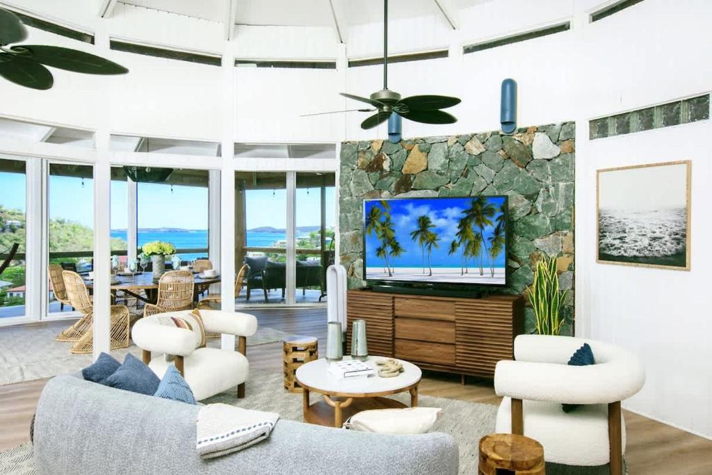 a living room with white furniture and a tv at Luxury Oceanview Villa Walk to Beach & Dining in Enighed