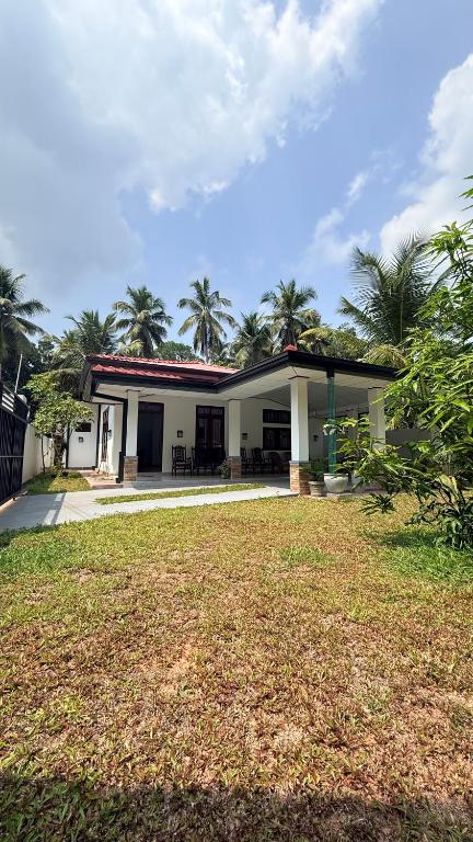a house with a lawn in front of it at The Grace Cottage - Negombo in Dagonna