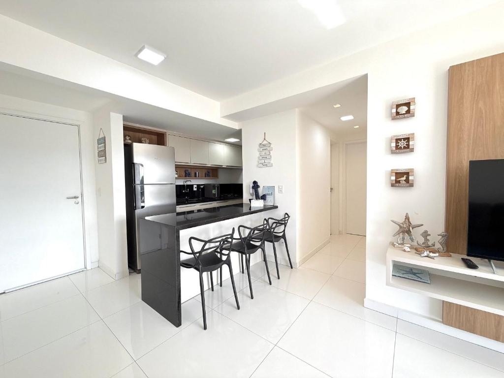 een keuken met een bar met krukken en een tv bij Apartamento com Área de Lazer na Cobertura in Cururupe