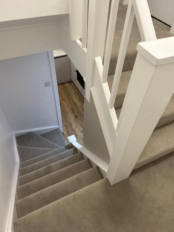 a stairway with a white stair case in a house at Luxury apartment in Guildford in Guildford