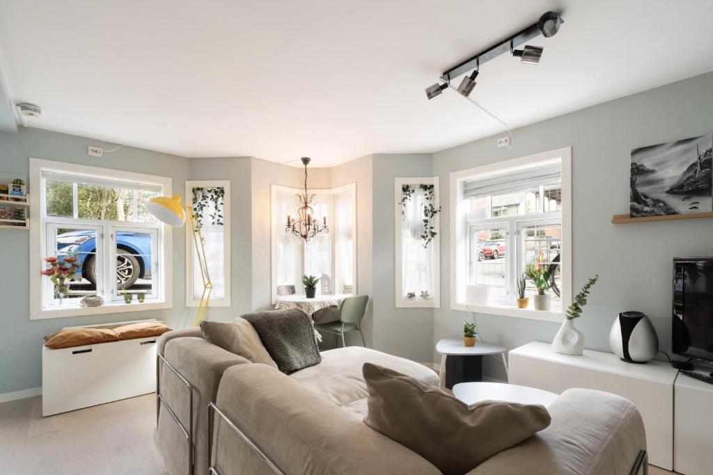 a living room with a couch and windows at Central apartement in Kristiansund in Kristiansund