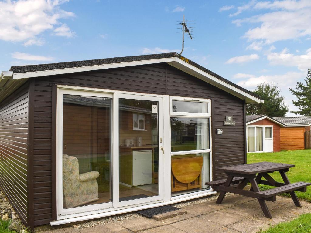 a small shed with a picnic table next to it at Old Town Cove - Uk47724 in St Merryn