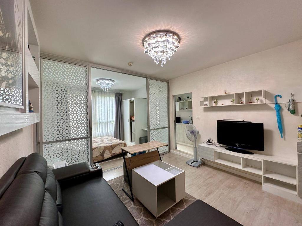 a living room with a couch and a television at DCondo Hyde near Central Plaza with Pool and Gym in Ban San Ton Ko (1)