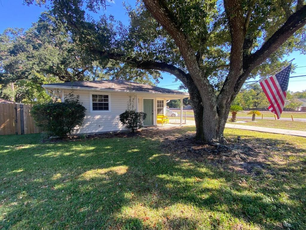 a house with an american flag in front of a tree at The Yellow Bench House in Long Beach