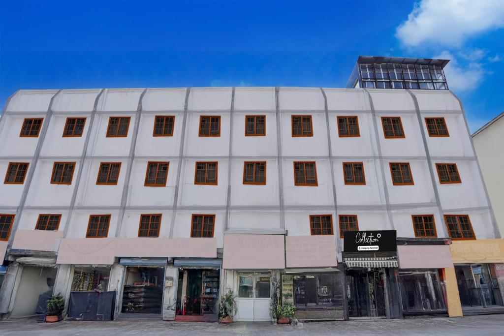 un edificio blanco con muchas ventanas en Collection O Warje Pune Formerly Choice Guest house, en Yerandwane