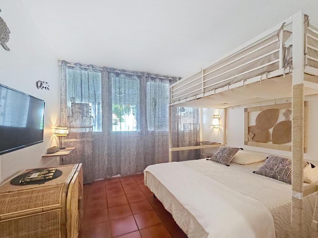 a bedroom with a bunk bed and a flat screen tv at Ti Mabouya Appartement Saint François in Saint-François